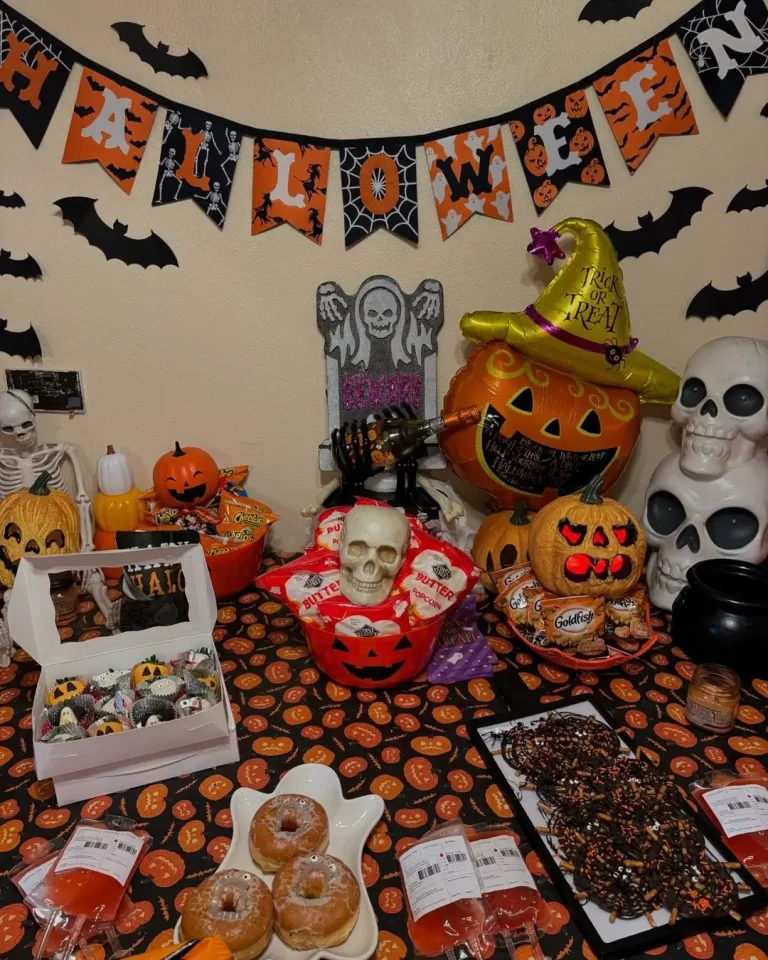 Spooky Festive Halloween Decoration Ideas for Office that Everyone Will Love 11 Halloween table setup with banner bats skull pumpkins and spooky treats. 3